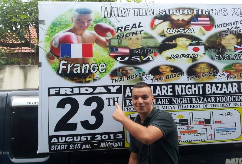 Combattant de muay thai devant l'affiche de son tournoi